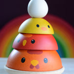 The PlanToys Chicken Nesting Toy shown with all the pieces and the egg stacked up. . 