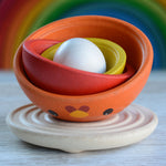 The PlanToys Chicken Nesting Toy shown with all the pieces nested inside each other on the wooden base. 