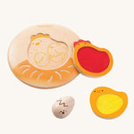 The PlanToys Chicken Puzzle on a plain background. The puzzle is shown on the second side with the pieces taken out of the puzzle. 