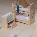 The bunk beds and the writing desk from the Plan Toys Children's Room Dolls House Furniture Set placed in a room in a dolls house. 
