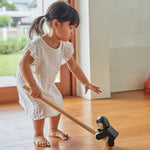 Girl reaching down to grab the PlanToys wooden climbing gorilla pull along toy