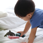 A close up of a child playing with the PlanToys Sea Life Set. 