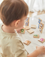 Close up of young boy stacking the pieces from the PlanToys wooden Waldorf animal guessing game