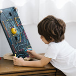 Child leaning over and drawing with a chalk on the PlanToys wooden wall ball game board