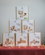 Six boxes of PlanToys natural wooden dollhouse furniture, stacked in a large discounted bundle at Babipur. 