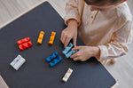 A child ordering pieces of the PlanToys wooden toy block puzzles in order of their colour.