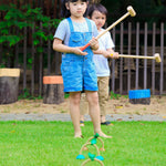 Children outdoors on a lawn with the  PlanToys Croquet set up in front of them. 