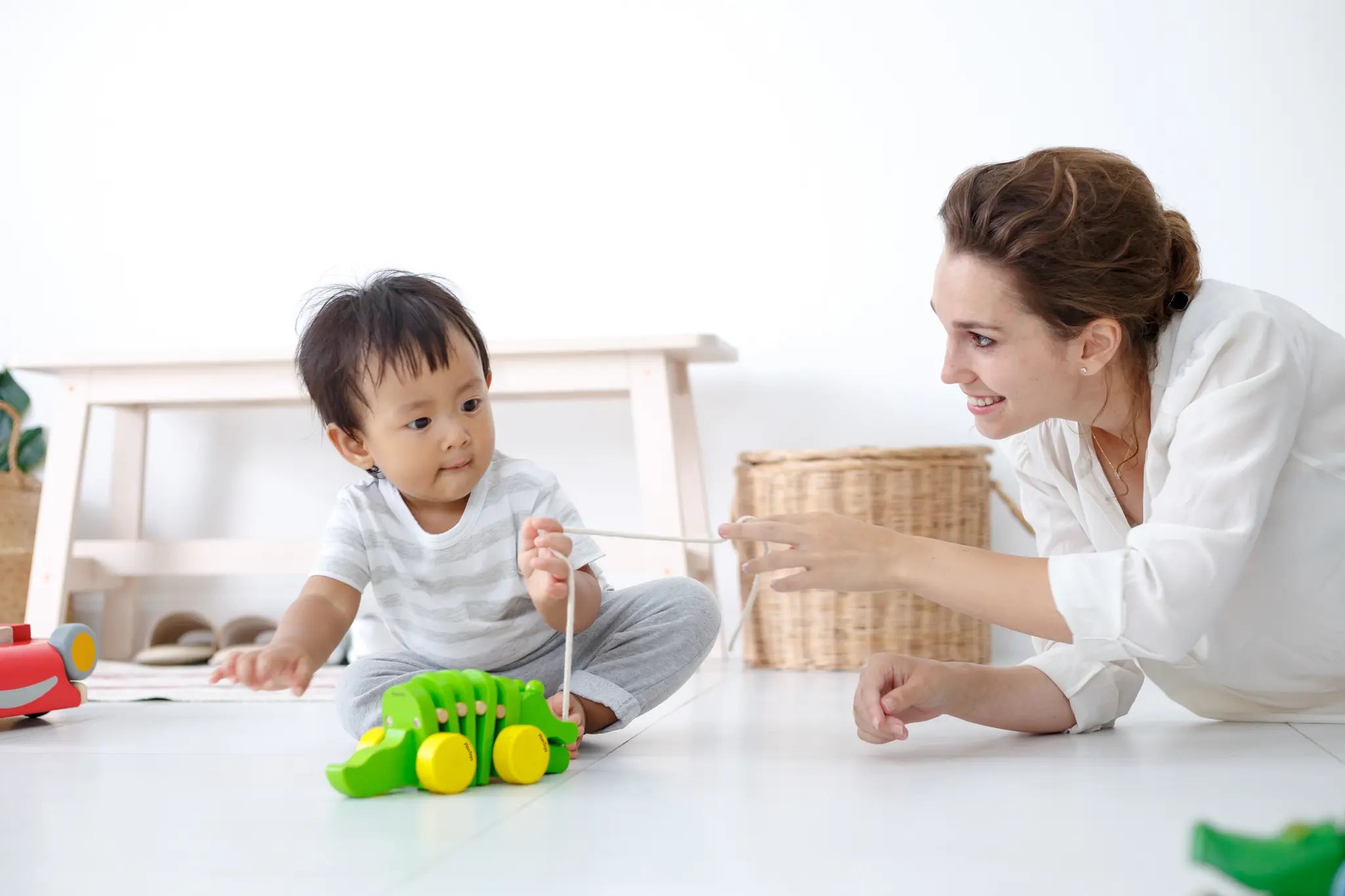 Mother and baby playing together with the Plan Toys Dancing Alligator wooden pull along toy