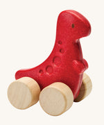 PlanToys dino rex wooden car toy. A red coloured, wooden tyrannosaurus rex dinosaur figure toy on wheels. PlanToys range of toys are made from sustainably sourced rubberwood, we're proud stockists of PlanToys here at Babipur. 