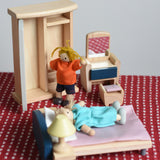 Two PlanToys peg dolls positioned in an imaginative play scene, with the orchard dollhouse wooden bedroom furniture. 