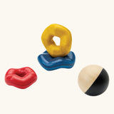 PlanToys wave ball stacker wooden stacking toy. Blue, yellow and red wavy rings with a black and white ball. 
