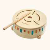Overhead view of a toddler drumming with the wooden mallet