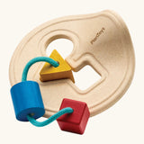 PlanToys first shape sorter wooden baby toy. Wood frame with three shapes attached on string, blue cylinder, red cube and yellow triangle. 