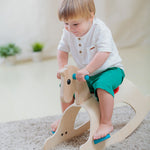 A child rocking on the PlanToys Palomino Rocking Horse. 