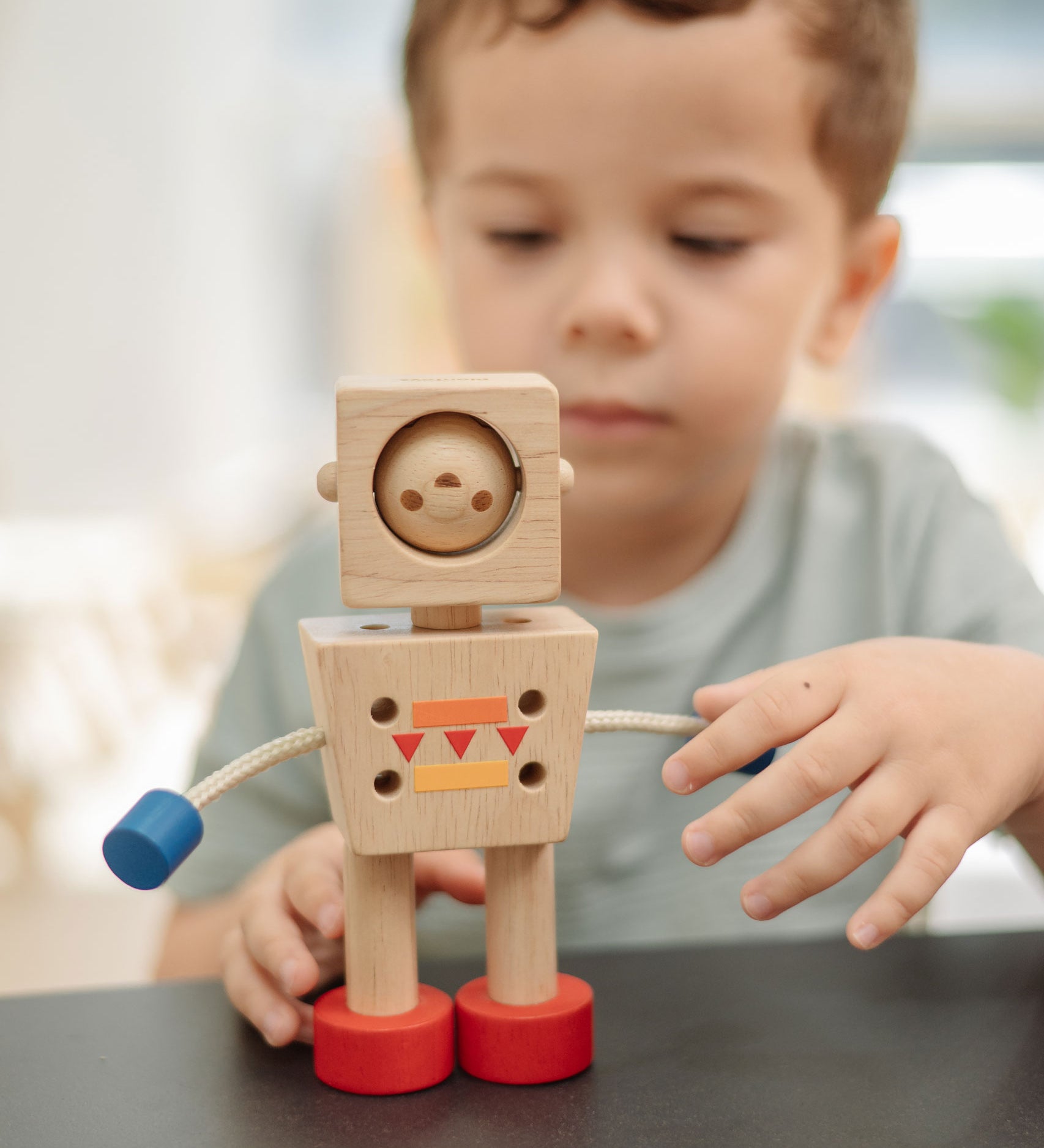 A child playing with the PlanToys Mood Bot Emotions Wooden Toy Robot. PlanToys range of toys are made from sustainably sourced rubberwood, we're proud stockists of PlanToys here at Babipur.  