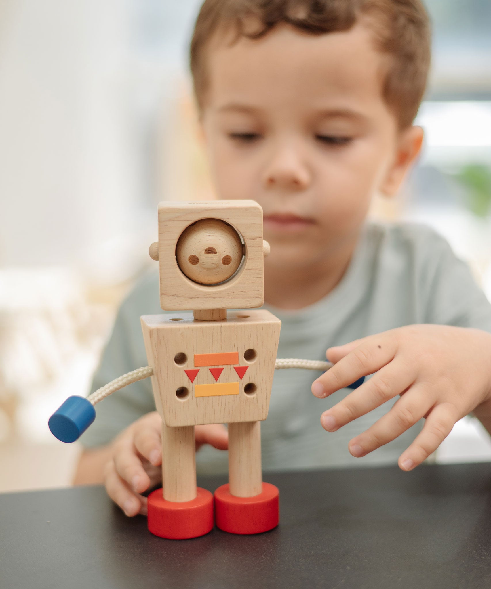 A child playing with the PlanToys Mood Bot Emotions Wooden Toy Robot. PlanToys range of toys are made from sustainably sourced rubberwood, we're proud stockists of PlanToys here at Babipur.  
