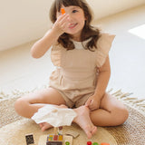 Child playing with the PlanToys Farmer's Market wooden toy playset holding a toy carrot in her hand. 