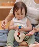 Toddler playing with the PlanToys first shape sorter wooden baby toy.