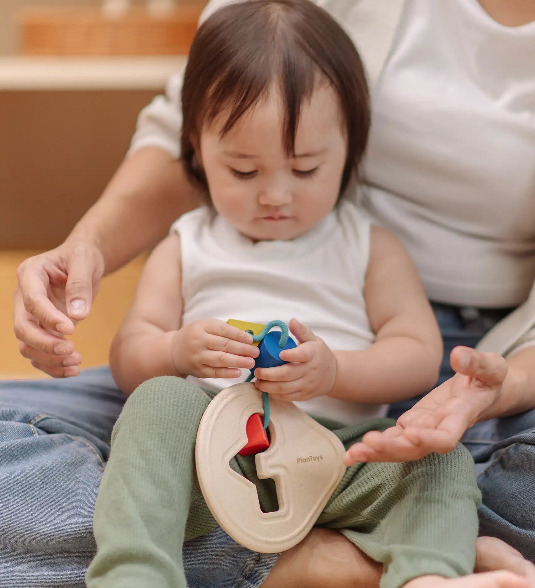 Toddler playing with the PlanToys first shape sorter wooden baby toy.