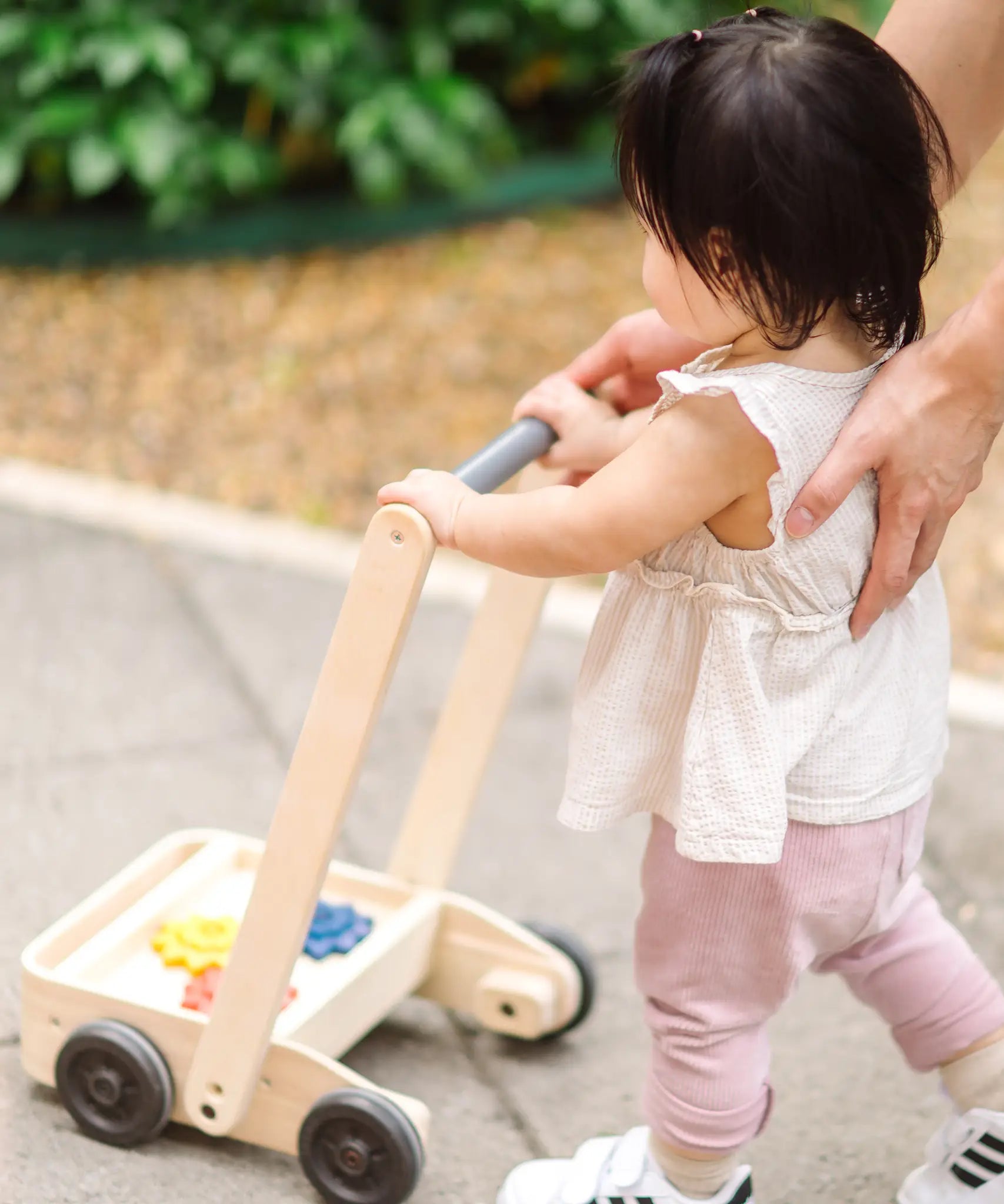Child pushing the PlanToys gear & go push along wooden baby walker. 