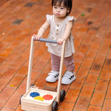 Child pushing the PlanToys gear & go push along wooden baby walker. 