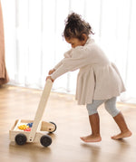 Child pushing the PlanToys gear & go push along wooden baby walker. 
