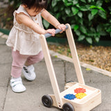 Child pushing the PlanToys gear & go push along wooden baby walker. 