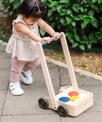Child pushing the PlanToys gear & go push along wooden baby walker. 