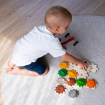 An overhead view of a child playing with the PlanToys Gear and Puzzle toy. 
