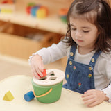 Child playing with the PlanToys geo sorting bucket wooden shape sorting toy. 