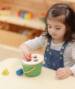 Child playing with the PlanToys geo sorting bucket wooden shape sorting toy. 