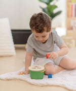 Child playing with the PlanToys geo sorting bucket wooden shape sorting toy. 