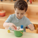 Child playing with the PlanToys geo sorting bucket wooden shape sorting toy. 