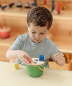 Child playing with the PlanToys geo sorting bucket wooden shape sorting toy. 