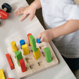A child playing with the PlanToys Geometric Peg Board.
