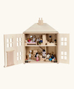 PlanToys wooden Georgian dollhouse children's toy. Front door are open and the rooms inside have been filled with wooden dolls house furniture and wooden dolls. 