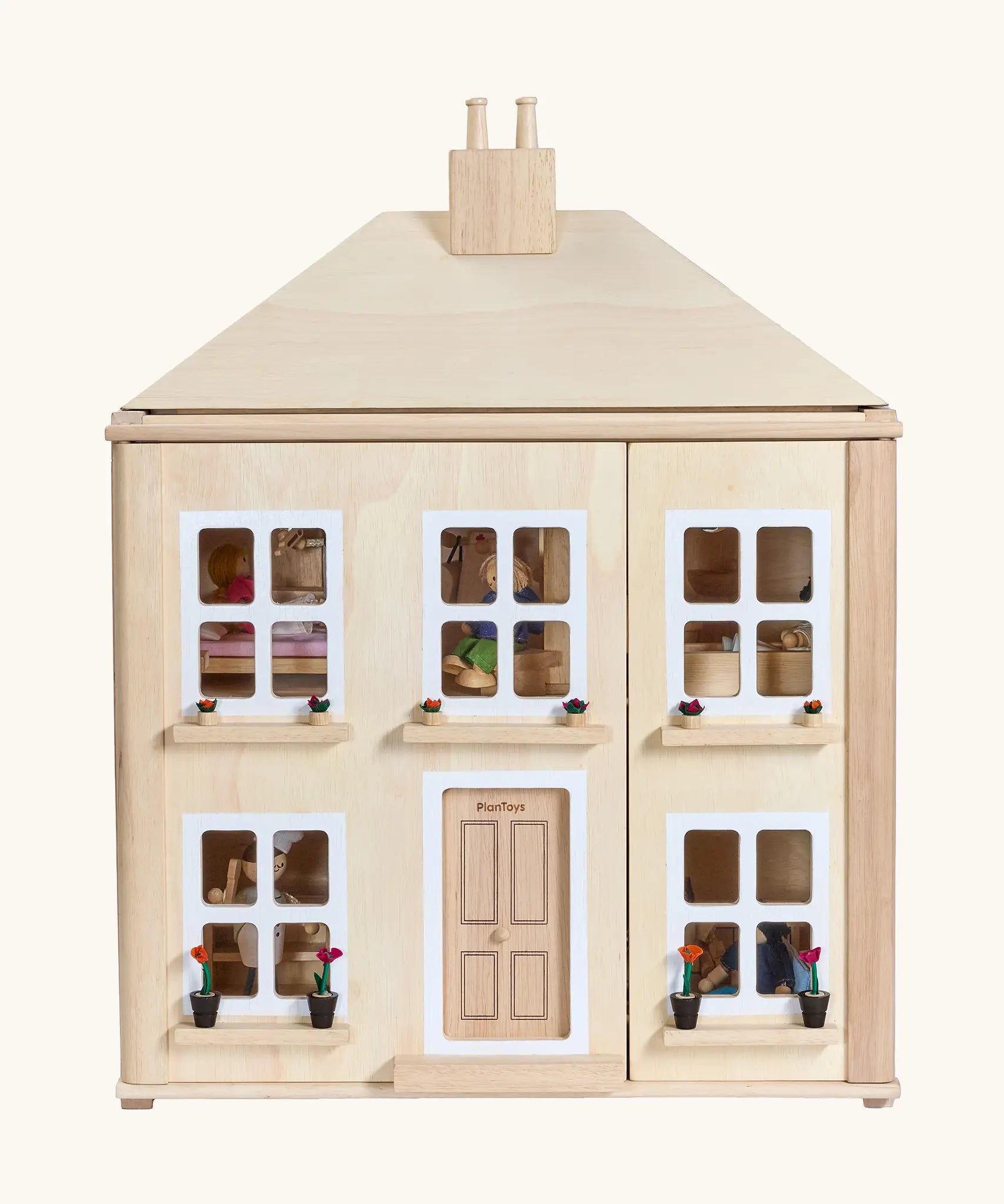 PlanToys wooden Georgian dollhouse children's toy.  Dolls can be seen inside. 