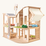 The Plan Toys Green Dolls' House and Furniture set on a plain background. 