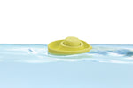 Close up of a PlanToys plastic-free natural rubber boat toy floating in some water