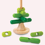 The PlanToys Stacking Tree Wooden Toy on a plain background. Three pieces have been taken off the base piece and placed besides the base. 