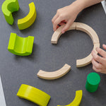 A close up of PlanToys Curve Blocks being played with by a child. 