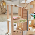 A close up of the recycling area at the side of the PlanToys Green Dolls' House. There are three compartments for recycling next to a rain water harvester. 