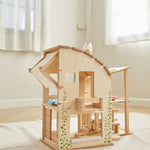 The PlanToys Green Dolls' House and Furniture Set placed on a white rug in the middle of a room.