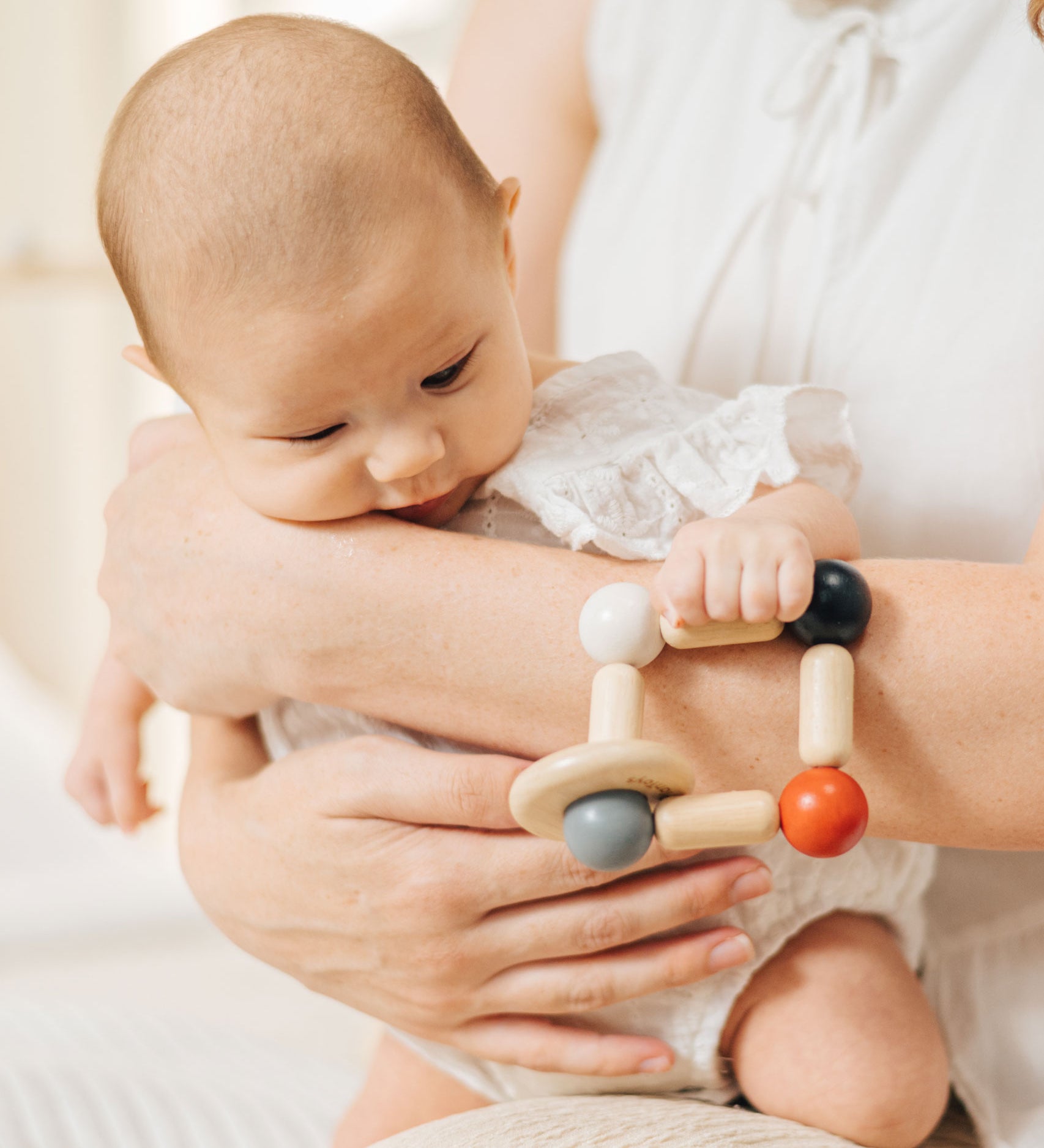 A baby clutching onto the PlanToys high contrast square clutching toy. PlanToys range of toys are made from sustainably sourced rubberwood, we're proud stockists of PlanToys here at Babipur. 