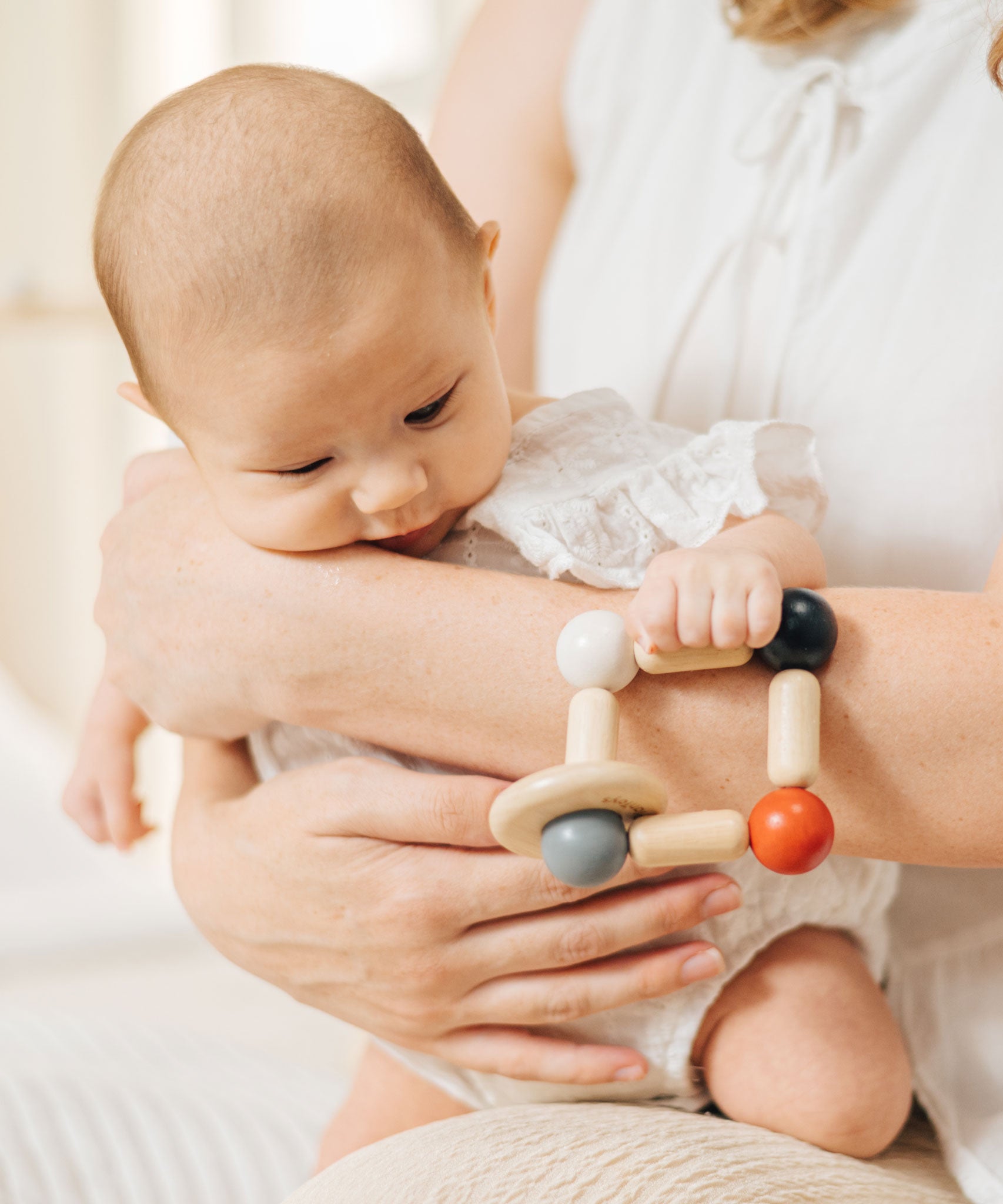 A baby clutching onto the PlanToys high contrast square clutching toy. PlanToys range of toys are made from sustainably sourced rubberwood, we're proud stockists of PlanToys here at Babipur. 