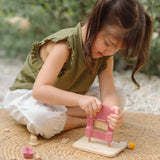 Child assembling the PlanToys ice cream shop wooden toy playset.