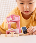 Child playing with the PlanToys ice cream shop wooden toy playset.