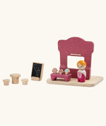 Back of the PlanToys ice cream shop wooden toy playset. Pink wooden shop with three ice cream cones, advert board, table and two seats and a worker figure.