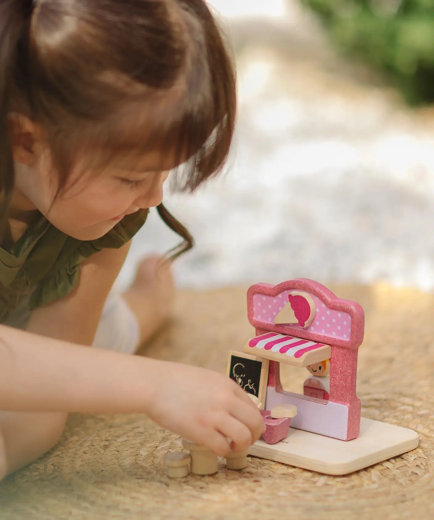 Child playing with the PlanToys ice cream shop wooden toy playset.