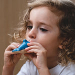 Child blowing through the PlanToys Wooden Dolphin Whistle Toy.